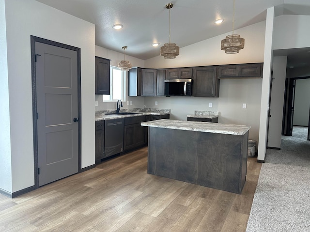 kitchen with stainless steel appliances, a sink, light wood-style floors, vaulted ceiling, and decorative light fixtures