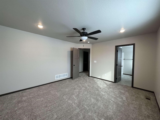 unfurnished bedroom featuring light carpet, baseboards, visible vents, and a textured ceiling