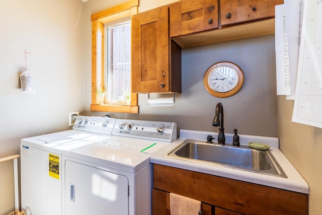 laundry room with washer and clothes dryer, cabinets, and sink