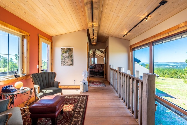 living area featuring wood ceiling, light hardwood / wood-style flooring, lofted ceiling with beams, and track lighting