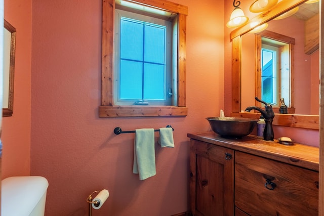 bathroom with vanity, toilet, and a healthy amount of sunlight