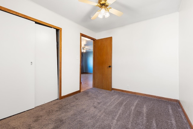 unfurnished bedroom featuring carpet flooring, ceiling fan, crown molding, and a closet