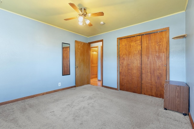 unfurnished bedroom featuring ceiling fan, crown molding, light carpet, and a closet