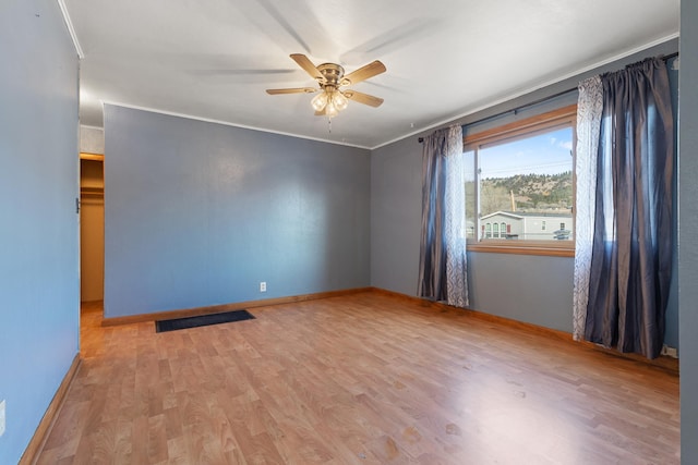 unfurnished room with ceiling fan, ornamental molding, and light wood-type flooring