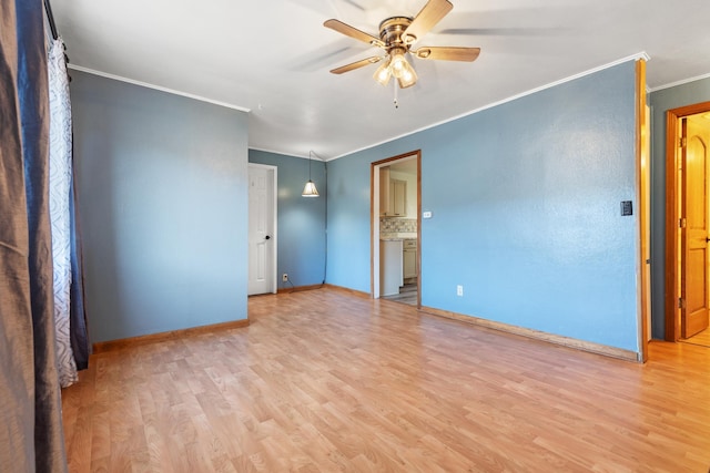 spare room with ceiling fan, ornamental molding, and light wood-type flooring