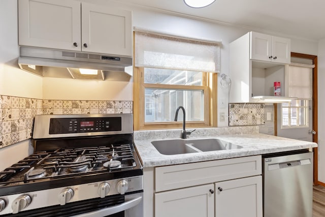 kitchen featuring appliances with stainless steel finishes, white cabinetry, a healthy amount of sunlight, and sink