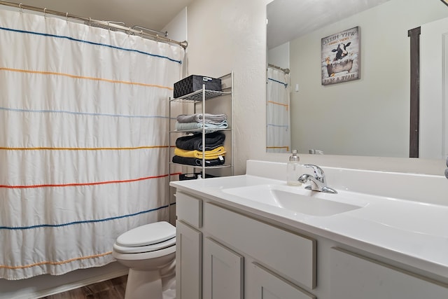 bathroom featuring hardwood / wood-style flooring, toilet, vanity, and walk in shower