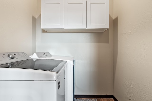 washroom featuring washing machine and clothes dryer and cabinets