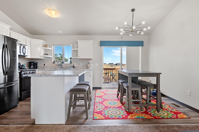 kitchen with decorative light fixtures, white cabinetry, a center island, and stainless steel appliances