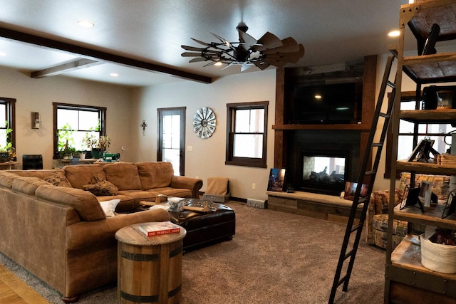 carpeted living room featuring beam ceiling, ceiling fan, and a multi sided fireplace