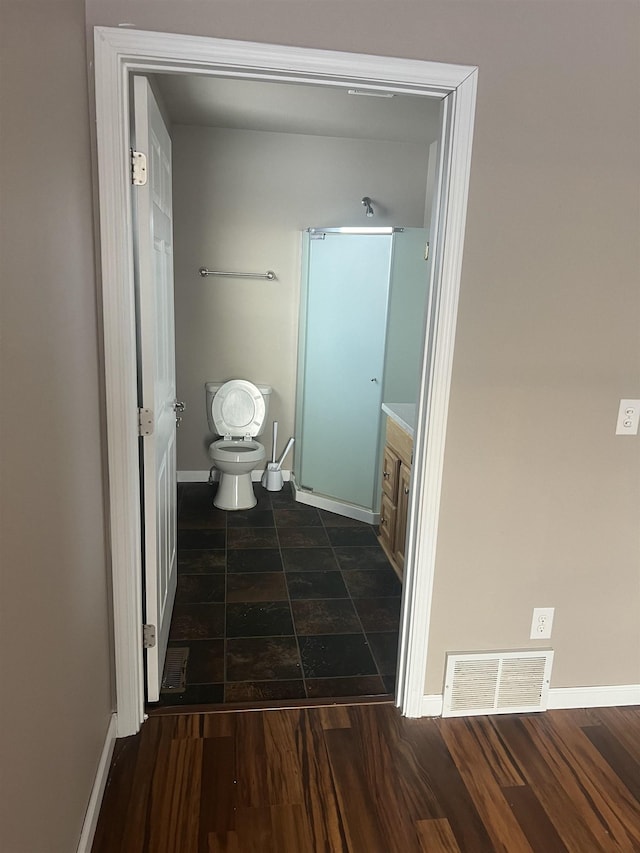 bathroom with wood-type flooring, vanity, and toilet