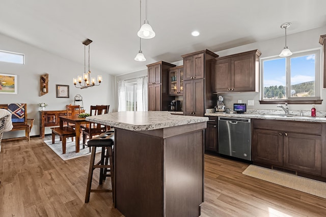 kitchen with dishwasher, pendant lighting, dark brown cabinets, and light hardwood / wood-style floors