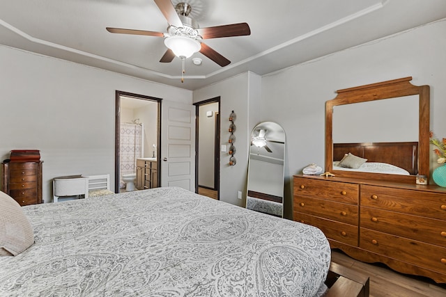 bedroom with ensuite bathroom, ceiling fan, and hardwood / wood-style flooring