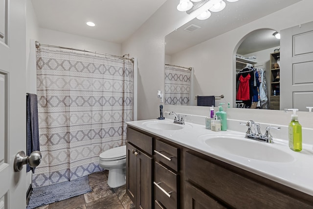 bathroom featuring vanity, toilet, and walk in shower