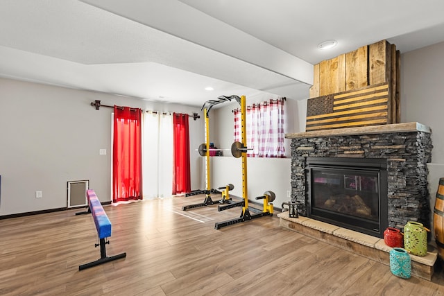 workout room featuring a fireplace, hardwood / wood-style floors, and a healthy amount of sunlight