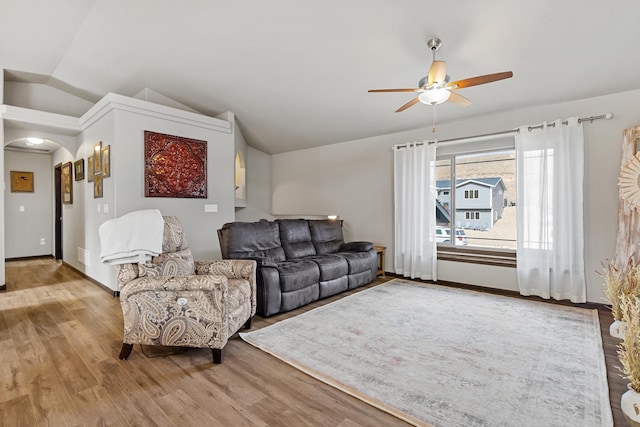 living room with wood-type flooring, vaulted ceiling, and ceiling fan