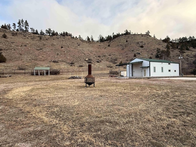 view of yard featuring a mountain view, a rural view, and an outdoor fire pit