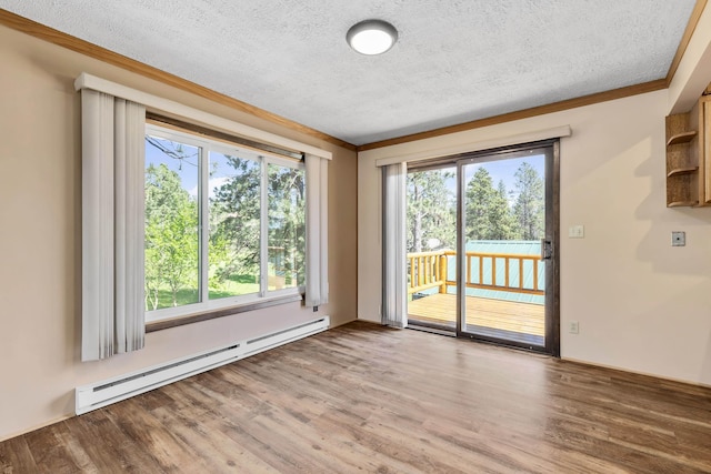 spare room with crown molding, light wood-type flooring, a textured ceiling, and a baseboard heating unit