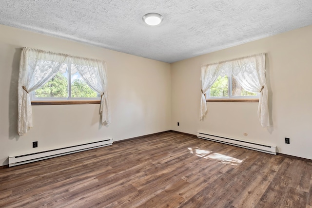 empty room with hardwood / wood-style floors, a textured ceiling, and a baseboard heating unit