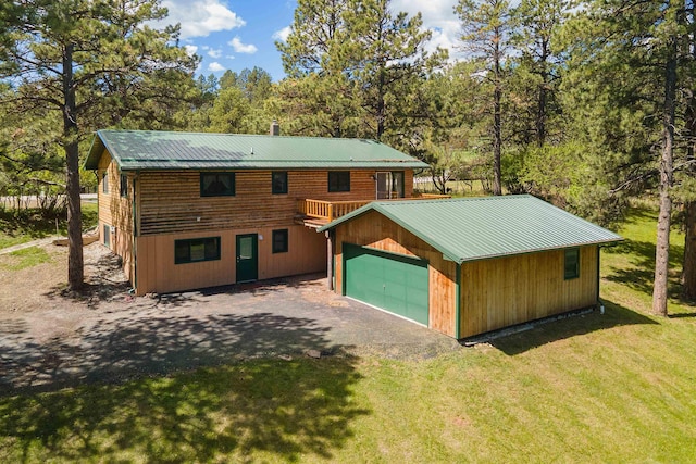 view of front of home featuring a garage, a front lawn, and a deck