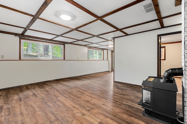 interior space featuring plenty of natural light, a wood stove, and coffered ceiling