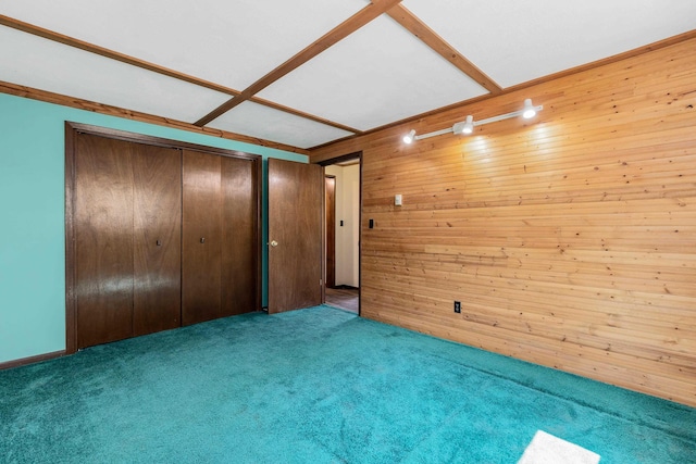 unfurnished bedroom with wood walls, a closet, and light carpet