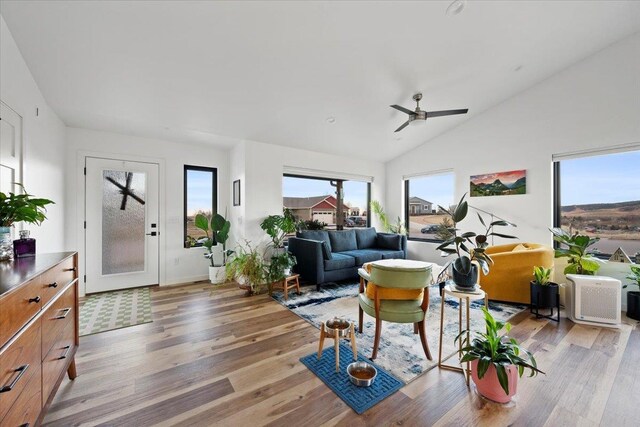 living room with ceiling fan, light hardwood / wood-style flooring, and lofted ceiling