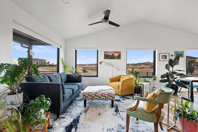 sitting room with ceiling fan, hardwood / wood-style floors, and vaulted ceiling