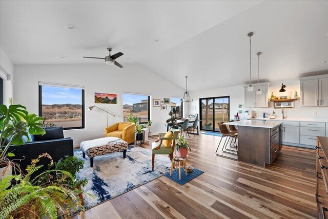 living room featuring hardwood / wood-style flooring, vaulted ceiling, and ceiling fan