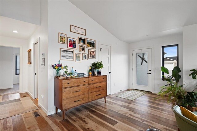 foyer featuring hardwood / wood-style flooring and vaulted ceiling