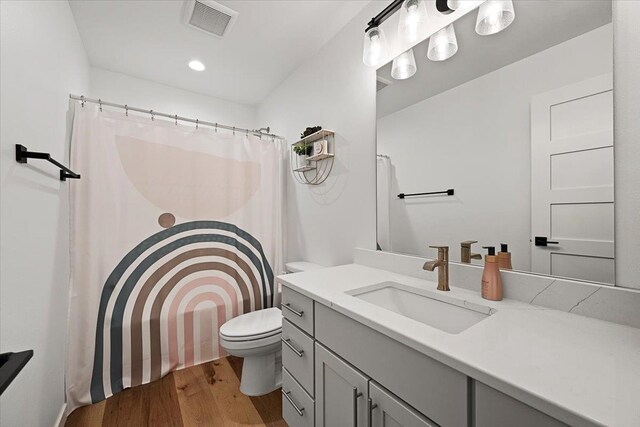 bathroom featuring wood-type flooring, vanity, and toilet