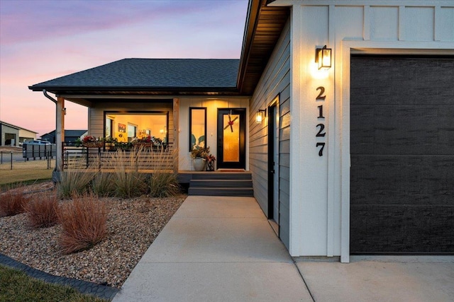 exterior entry at dusk with a garage