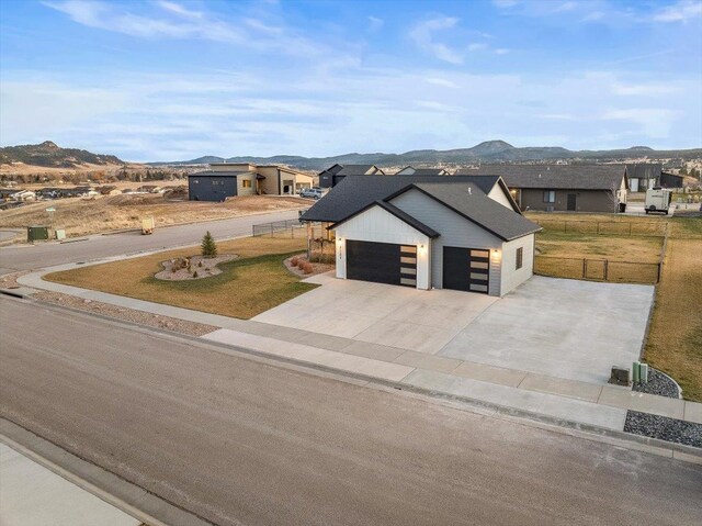 view of front of house with a mountain view and a front lawn