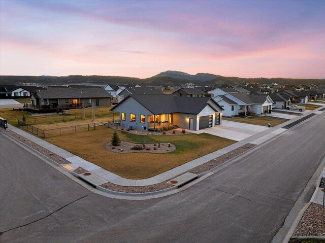 view of front facade featuring a mountain view, a yard, and a garage