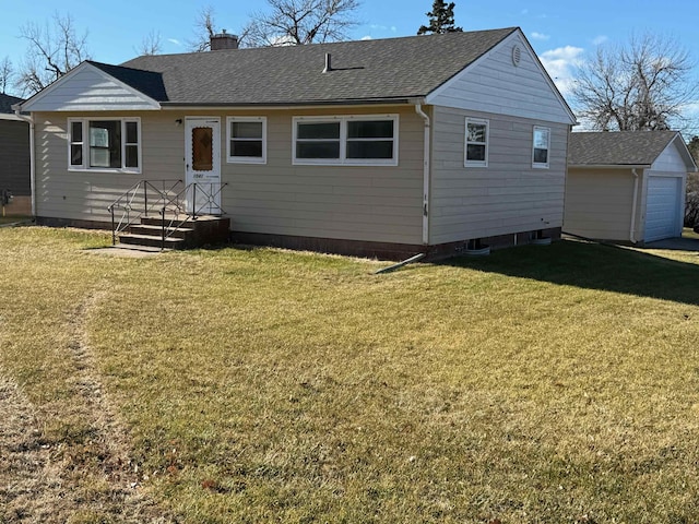 back of house with a yard and a garage