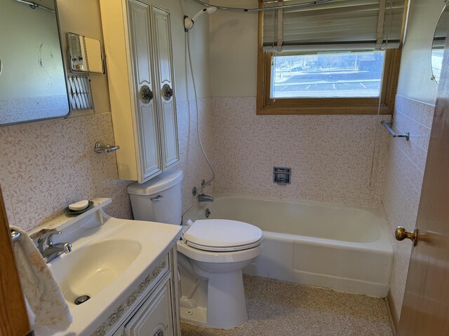 full bathroom with vanity, toilet, tile walls, and bathing tub / shower combination