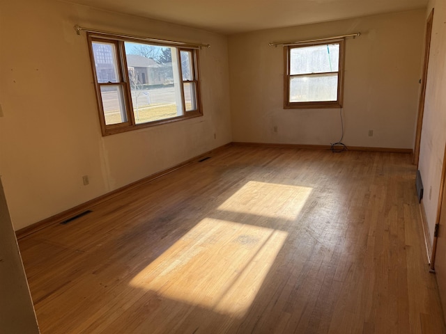 spare room featuring plenty of natural light and light hardwood / wood-style floors