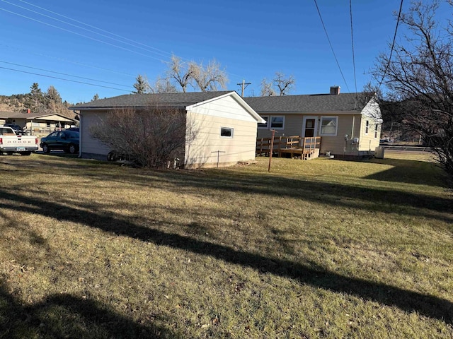 rear view of property featuring a lawn and a wooden deck