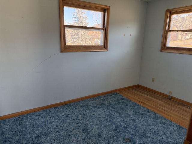 unfurnished room with hardwood / wood-style flooring and a healthy amount of sunlight