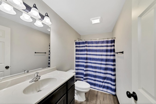 bathroom with curtained shower, vanity, wood-type flooring, and toilet