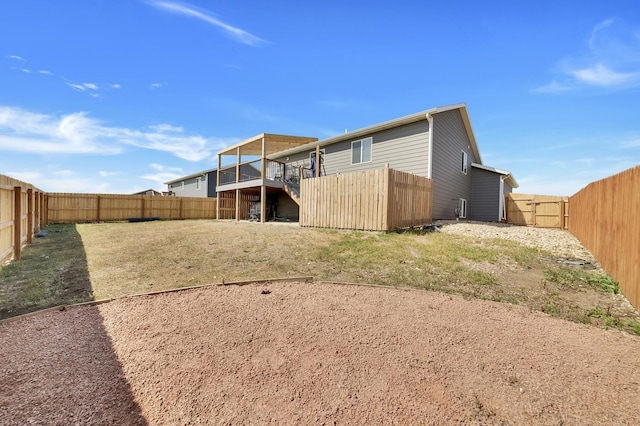 back of property with a lawn and a deck