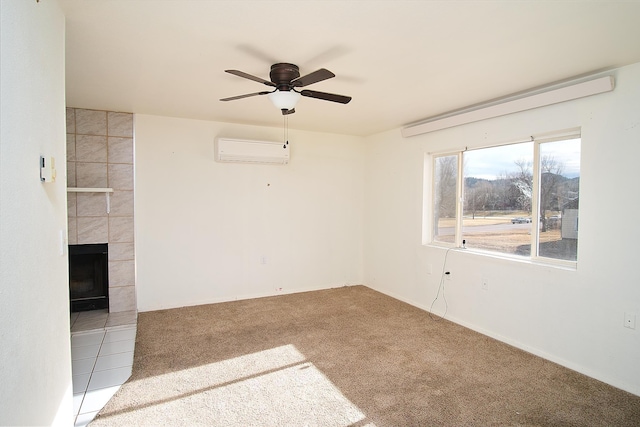 carpeted spare room with a wall mounted AC, ceiling fan, and a tile fireplace