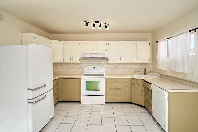 kitchen featuring backsplash, sink, light tile patterned floors, and white appliances