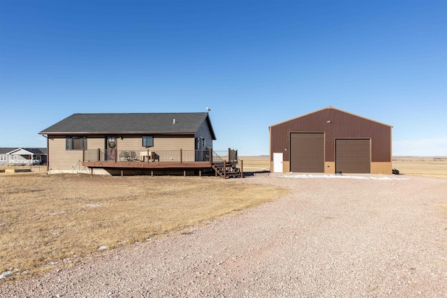 rear view of house with a wooden deck, an outdoor structure, and a garage