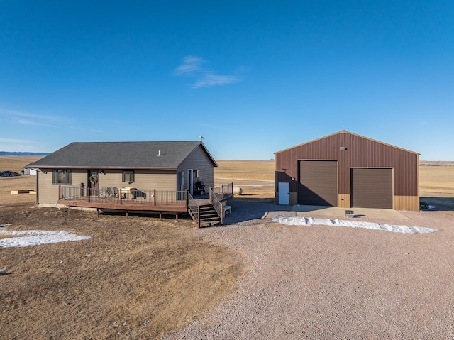 view of front of home with an outbuilding, a rural view, a deck, and a garage