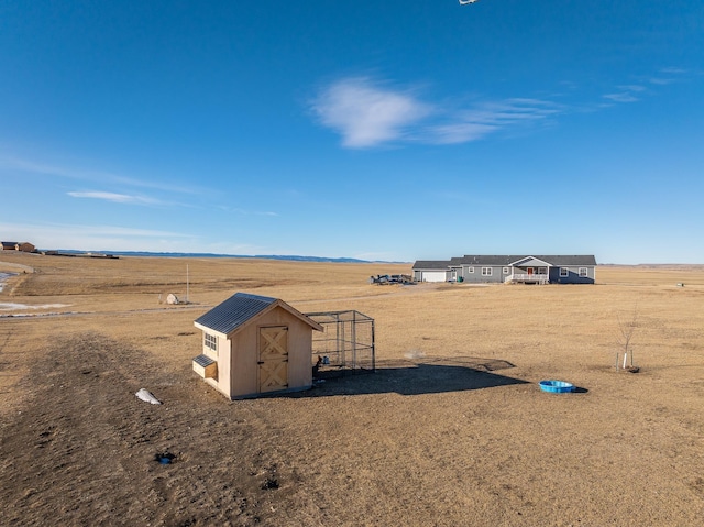 view of yard featuring a rural view and a storage unit