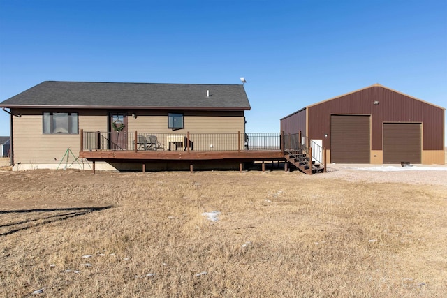 back of house featuring a deck, an outdoor structure, and a garage