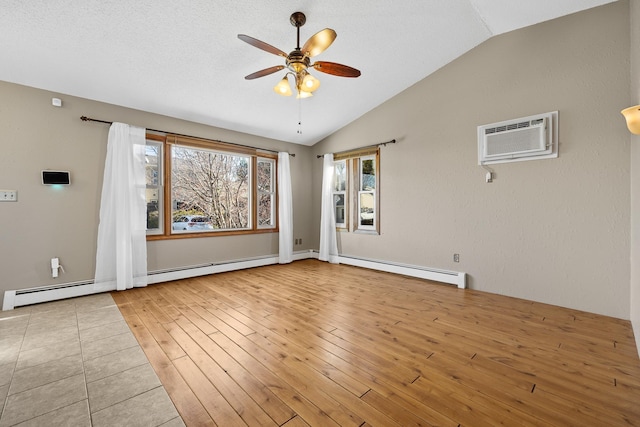 empty room featuring ceiling fan, a baseboard heating unit, a wall mounted AC, light hardwood / wood-style floors, and vaulted ceiling