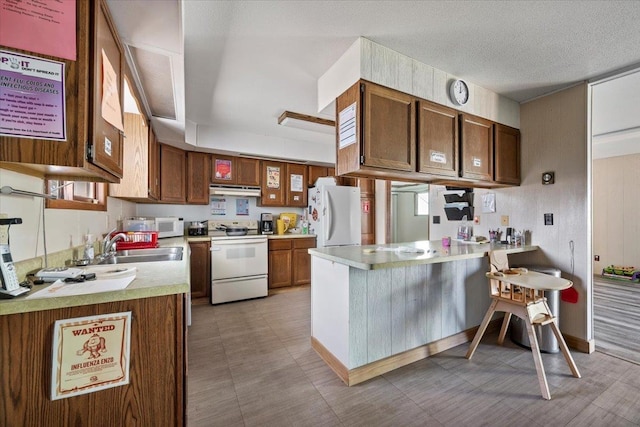 kitchen featuring kitchen peninsula, a textured ceiling, white appliances, and sink