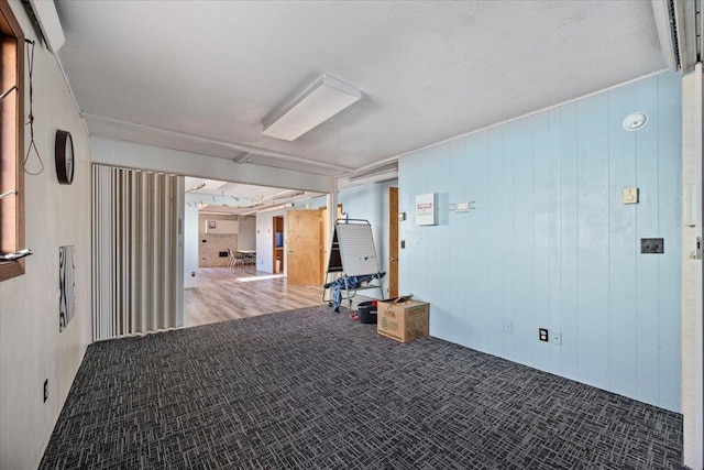 unfurnished room featuring wood walls